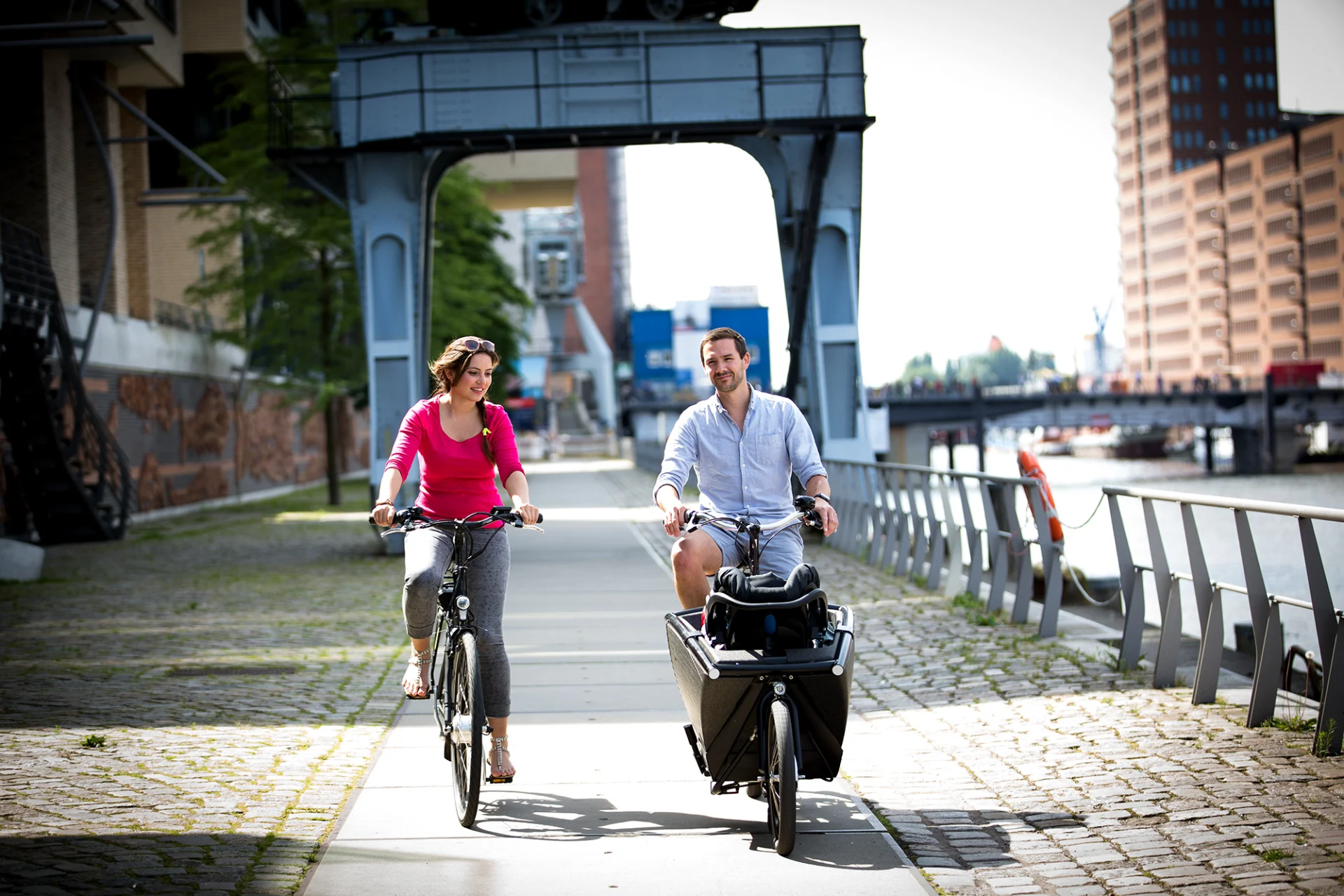 Urban Arrow Family — Family fährt mit Ebikes an der Elbe in der Hafencity Hamburg
